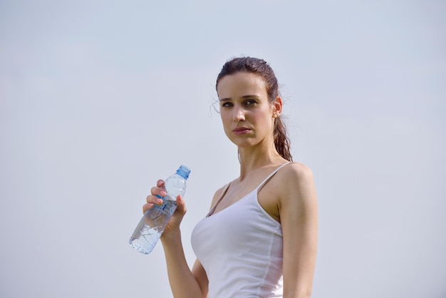 Młoda piękna kobieta wody pitnej po ćwiczeniach fitness i joggingu na świeżym powietrzu