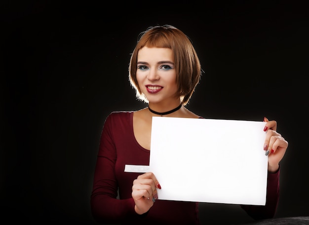 Młoda piękna kobieta z czystą białą kartką papieru