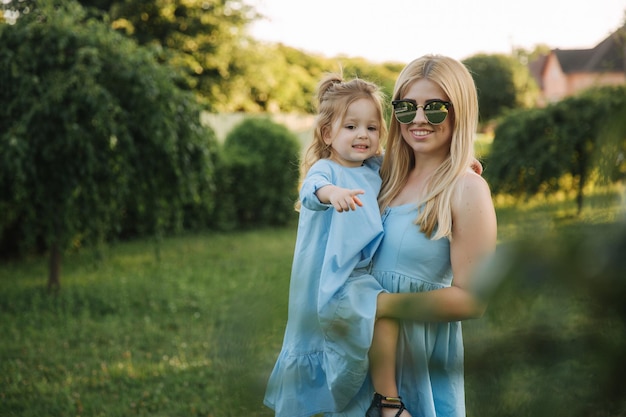 Młoda piękna kobieta z jej małą śliczną córką Młoda córka ściska matkę w lato parku