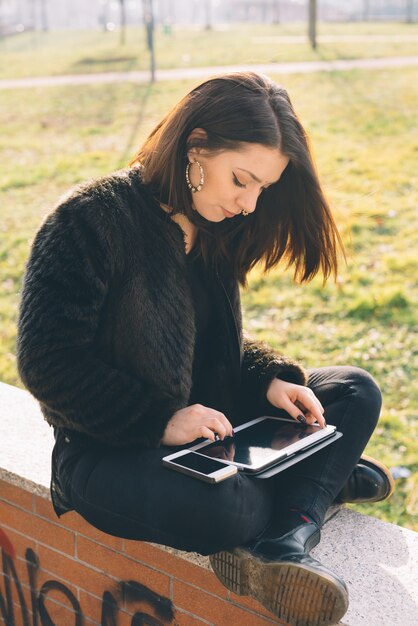 młoda piękna kobieta za pomocą tabletu i smartfona