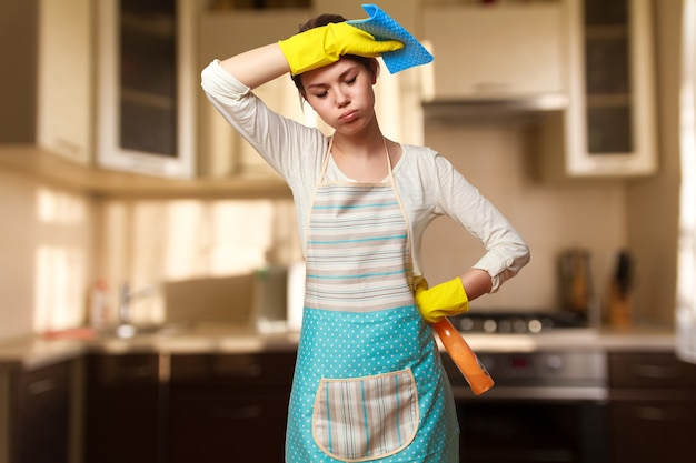 Zdjęcie młoda piękna kobieta zaangażowana w sprzątanie kuchni