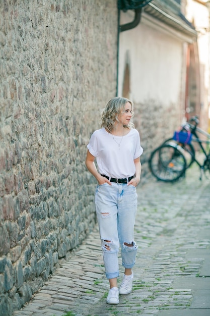 Młoda piękna niebieskooka blondynka w centrum europejskiego miasta Portret stylowej modelki w codziennych ubraniach Szczęśliwa młodość
