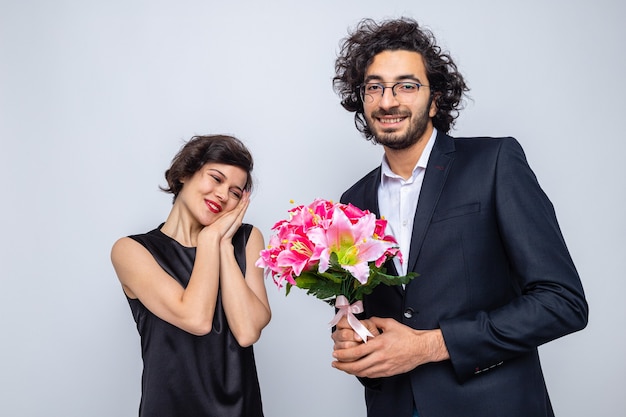 Młoda piękna para szczęśliwy mężczyzna daje bukiet kwiatów swojej uroczej dziewczynie szczęśliwej w miłości świętującej walentynki
