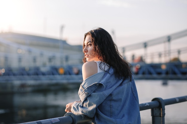 Młoda Piękna Uśmiechnięta Hipster Kobieta W Modnych Letnich Ubraniach Seksowna Beztroska Modelka Pozuje Na Tle Ulicy Europy O Zachodzie Słońca Pozytywna Brunetka Kobieta Wesoła I Szczęśliwa