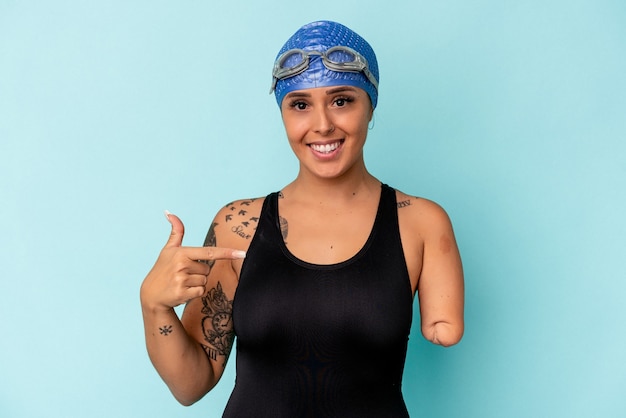 Młoda pływaczka kaukaska kobieta z jednym ramieniem na białym tle na niebieskim tle osoba wskazująca ręcznie na miejsce na koszulkę, dumna i pewna siebie