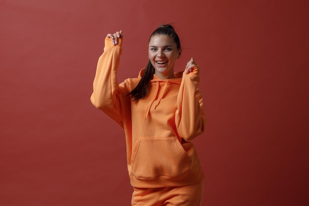 Zdjęcie młoda pozytywna uśmiechnięta kobieta w pomarańczowym fitness sportowym stroju sukiennym taniec
