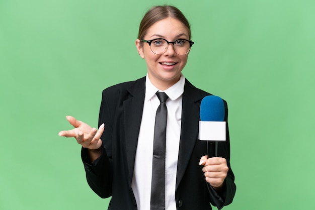 Młoda prezenterka telewizyjna kaukaska kobieta na białym tle ze zszokowanym wyrazem twarzy