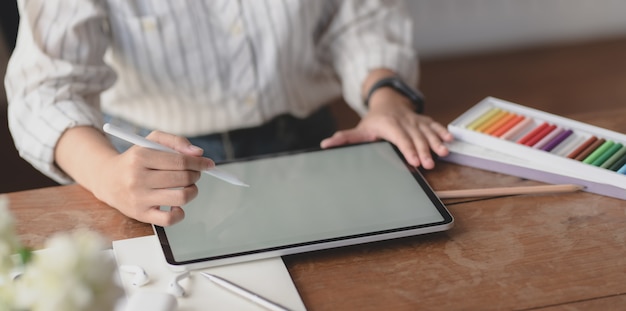 młoda profesjonalna projektantka pracująca na pustym ekranie tabletu w jej obszarze roboczym