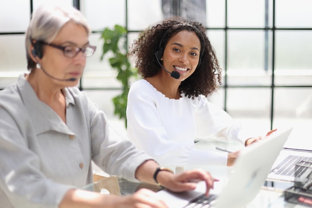 Młoda przyjazna agentka operatora ze słuchawkami pracująca w call center