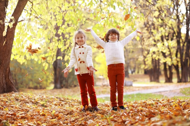 Młoda rodzina na spacerze w jesiennym parku w słoneczny dzień. Szczęście być razem.