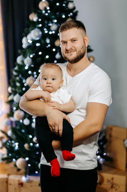 Młoda rodzina świętuje Boże Narodzenie w domu. Szczęśliwa młoda rodzina, ciesząc się razem wakacje.