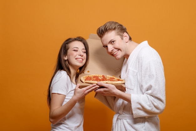 Młoda Rodzina W Domowych Ubraniach Na żółtej Pomarańczy W Kwarantannie Z Włoską Pizzą Pepperoni Dobre Relacje Rodzinne