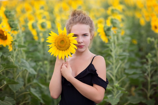 Młoda romantyczna dziewczyna w polu z słonecznikami