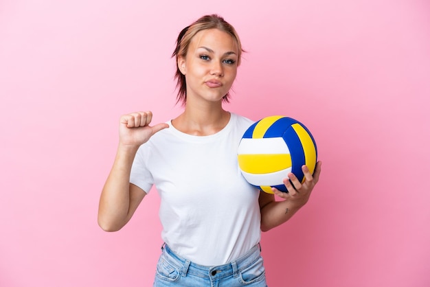 Młoda Rosjanka grająca w siatkówkę na różowym tle dumna i zadowolona