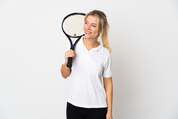 Młoda Rosjanka tenisistka na białym tle biały patrząc z boku i uśmiechnięta