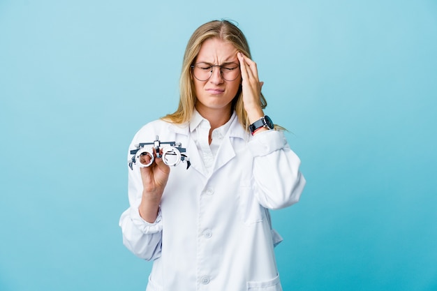 Młoda rosyjska optometrysta kobieta na niebiesko dotykając świątynie i mając ból głowy.