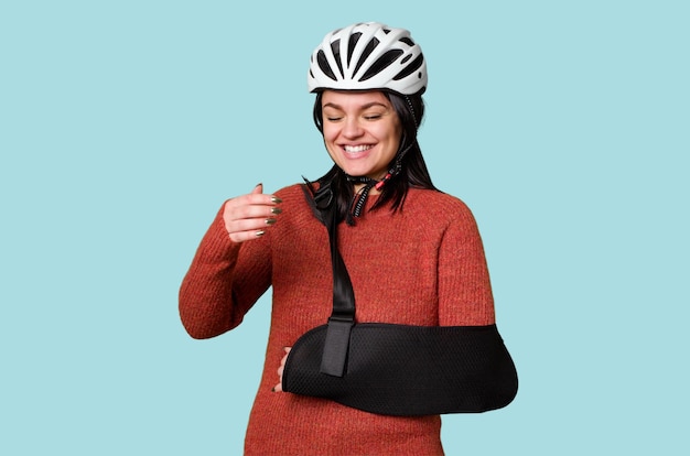 Młoda rowerzystka z urazem drogowym, nosząca temblak, wykazuje dyskomfort lub wyraz bólu