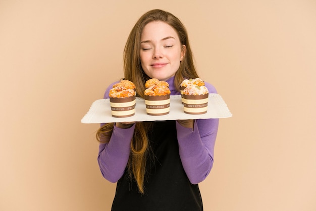 Młoda Ruda Kobieta Trzymająca Tacę Muffins Wyciętą Na Białym Tle