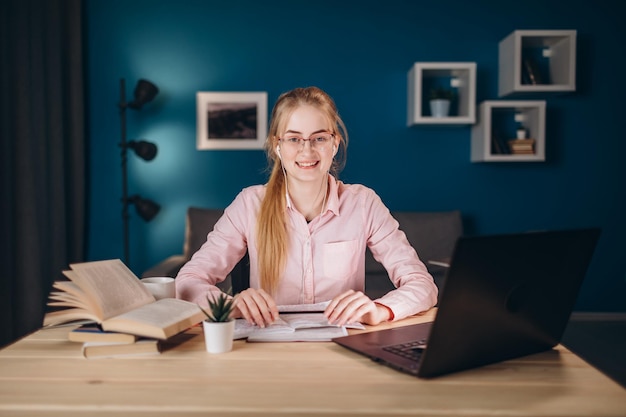 Młoda śliczna imbirowa studencka dziewczyna przy biurkiem