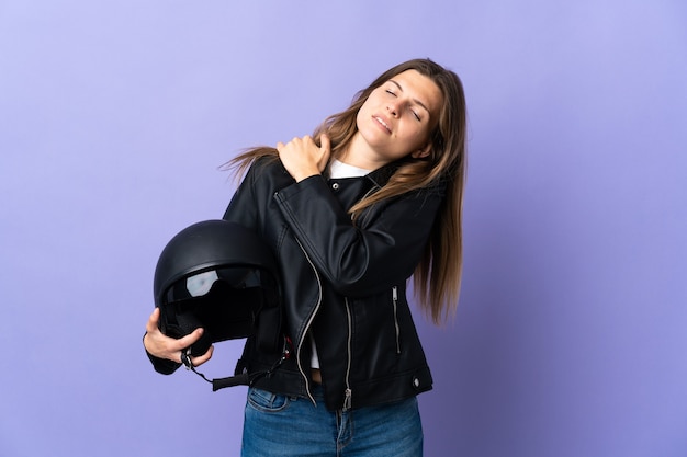 Młoda słowacka kobieta trzymająca kask motocyklowy na fioletowym tle cierpi na ból barku z powodu wysiłku