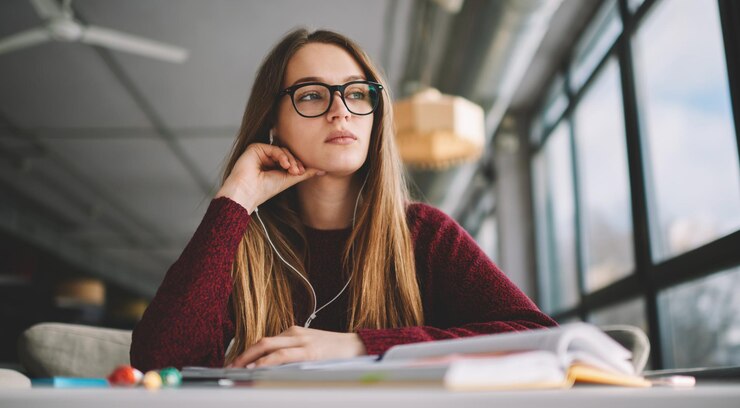 młoda śniąca hipsterka studiująca kurs nauki przez audiobooka i słuchawki