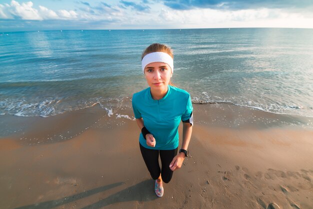 Młoda Sporty Dziewczyna Pracująca Na Plaży Przy Wschodem Słońca W Ranku Out