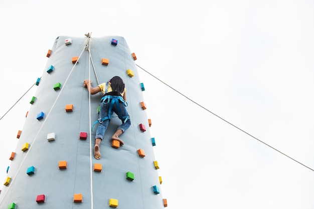Młoda sporty kobieta wspina się up na praktyki góry ścianie plenerowej, tylni widok