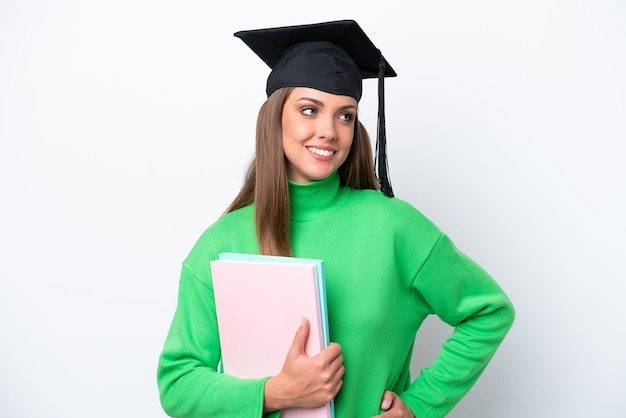 Młoda Studentka Kaukaska Kobieta Na Białym Tle Pozuje Z Rękami Na Biodrach I Uśmiecha Się