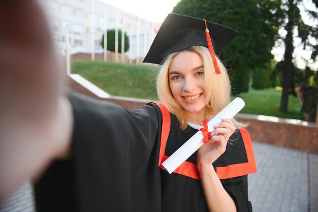 Zdjęcie młoda studentka kończąca studia na uniwersytecie robi selfie