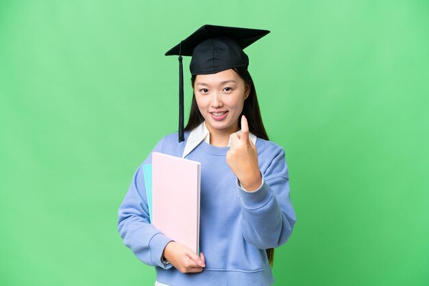 Młoda studentka na odizolowanym tle klucza chrominancji robi nadchodzący gest