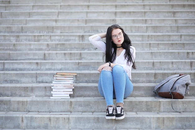Młoda studentka na ulicy z plecakiem i książkami