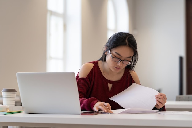 Młoda studentka pracująca w kampusie przygotowuje się do egzaminu lub poważnego testu na uniwersytecie lub w college'u