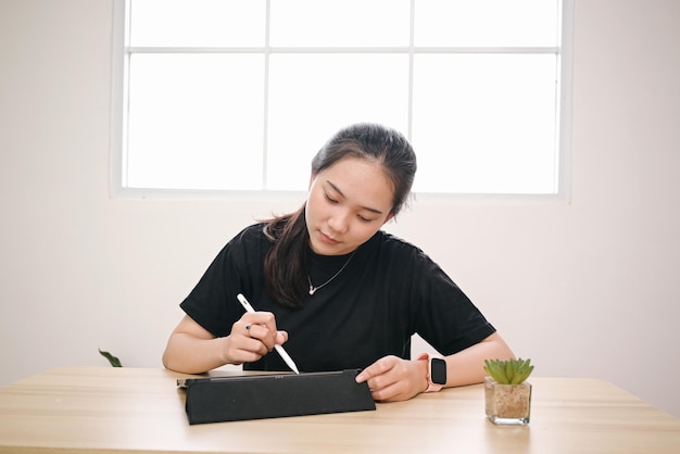 Młoda studentka pracuje nad tabletem w domu