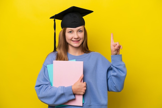 Młoda studentka Rosjanka odizolowana na żółtym tle wskazująca świetny pomysł