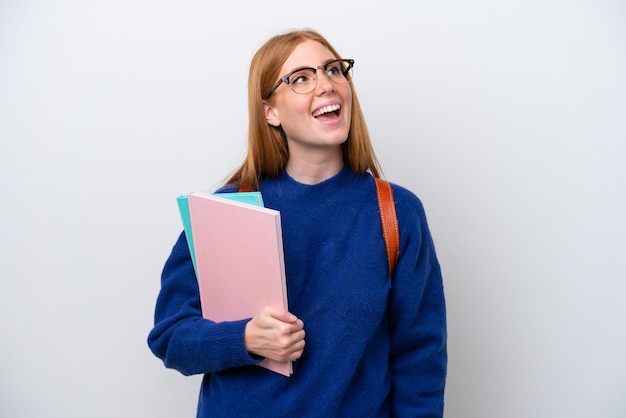 Młoda studentka ruda kobieta na białym tle śmiejąc się