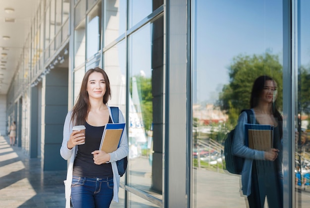 Młoda studentka, z książkami i plecakiem. Chodzenie na wykład i picie kawy. Myślenie o nadchodzącym dniu. Koncepcja stylu życia i edukacji