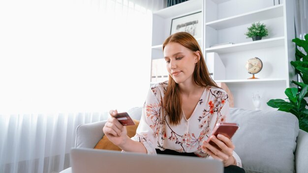 Młoda szczęśliwa kobieta kupuje produkt poprzez zakupy online z najwyższym bezpieczeństwem