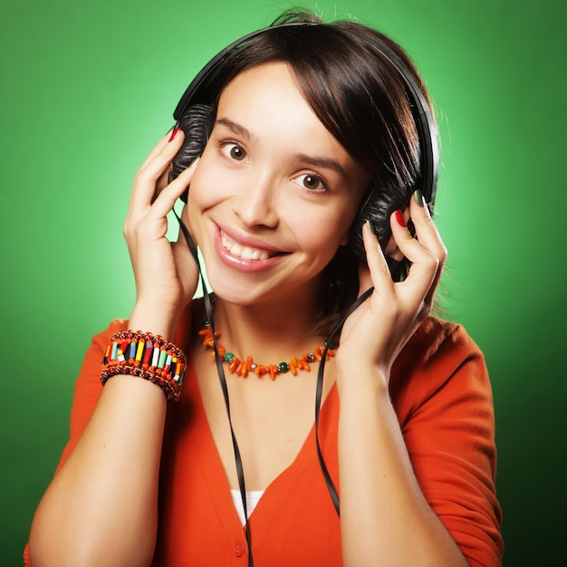 Młoda szczęśliwa kobieta słucha muzykę z hełmofonami
