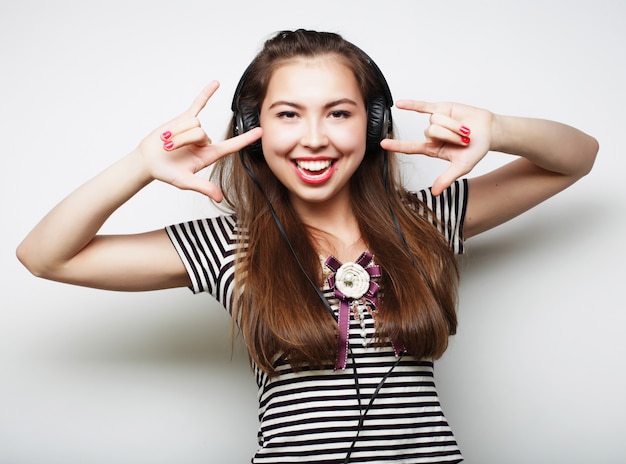 Młoda szczęśliwa kobieta słucha muzykę z hełmofonami