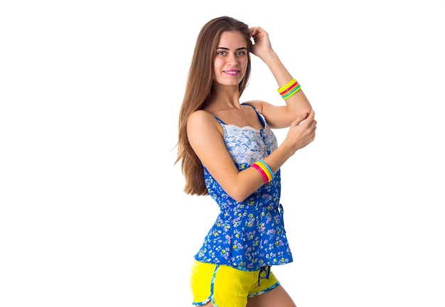 Młoda Szczęśliwa Kobieta W Niebieskiej Koszulce I żółtych Spodenkach Trzymająca Się Za Ręce Na Głowie W Studio