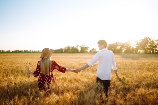 Młoda szczęśliwa para przytulanie na polu pszenicy na zachód słońca Wspólny czas