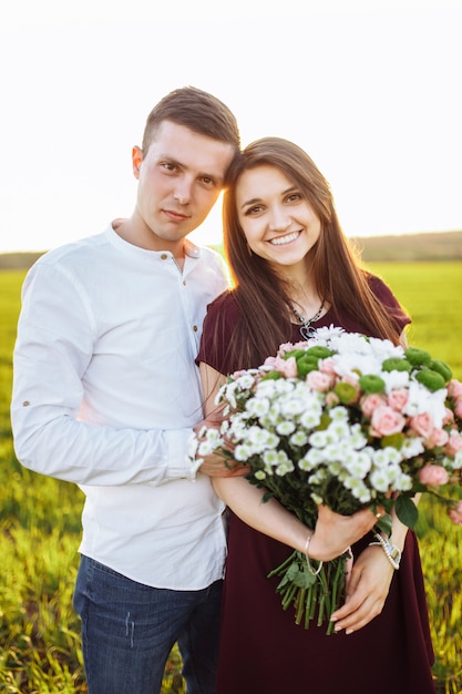 Młoda szczęśliwa para w miłości, kobieta trzyma kwiaty, szczęśliwa i ciesz się swoim towarzystwem