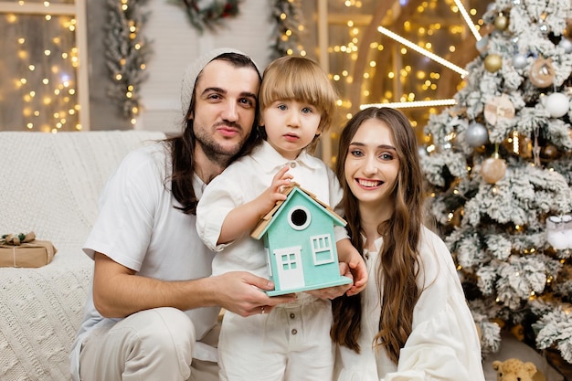 Młoda szczęśliwa rodzina świętuje Boże Narodzenie przy choince