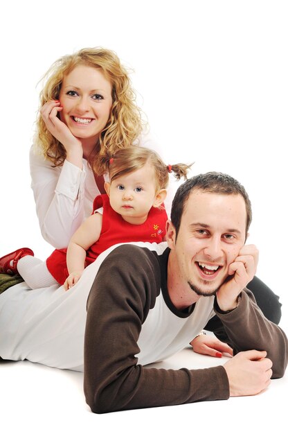 Młoda szczęśliwa rodzina z pięknym dzieckiem bawiącym się i uśmiechającym się odizolowanym na białym w studiu