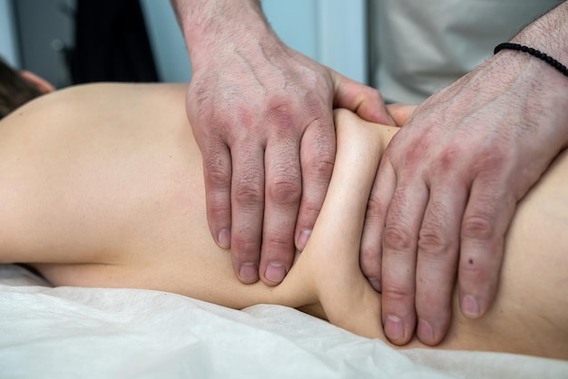 Młoda szczupła kobieta ma relaksujący masaż pleców w spa