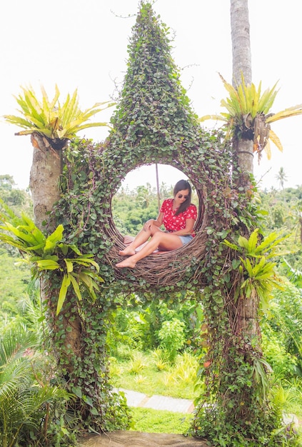 Młoda turystka ciesząca się podróżą po wyspie Bali w Indonezji Zatrzymuje się na pięknym wzgórzu z widokiem na duże jezioro Fotografuje w gnieździe słomy środowisko naturalne Styl życia