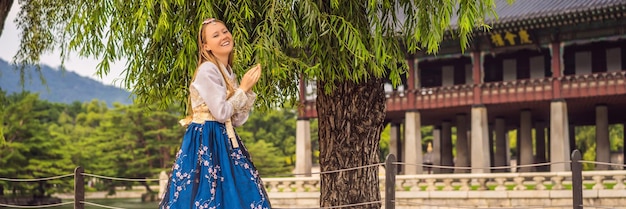 Młoda turystka kaukaska w narodowej koreańskiej sukience hanbok Podróż do Korei koncepcja Koreańska odzież narodowa Rozrywka dla turystów przymierzających narodową koreańską odzież BANNER DŁUGI FORMAT