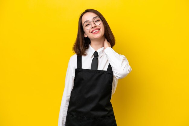 Młoda ukraińska kelnerka odizolowana na żółtym tle śmiejąca się