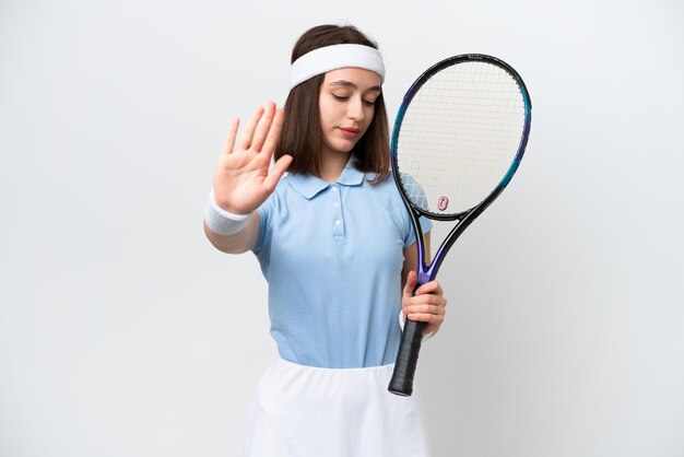 Młoda ukraińska tenisistka na białym tle robi gest zatrzymania i rozczarowana