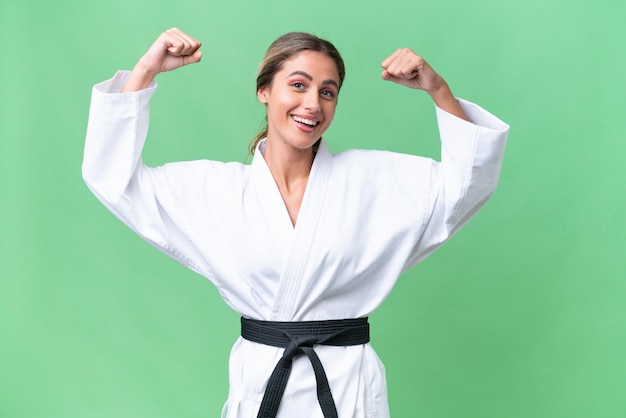Młoda Urugwajska kobieta na odosobnionym tle robi karate i robi silny gest